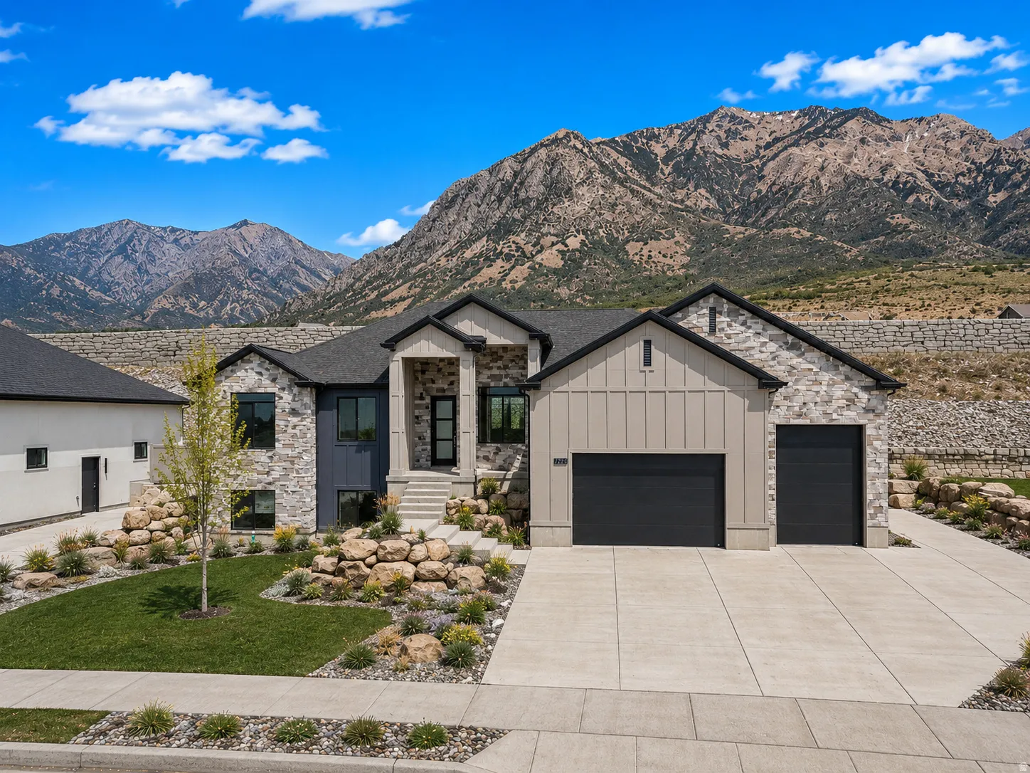 Contemporary stone and siding exterior with a dark shingle roof