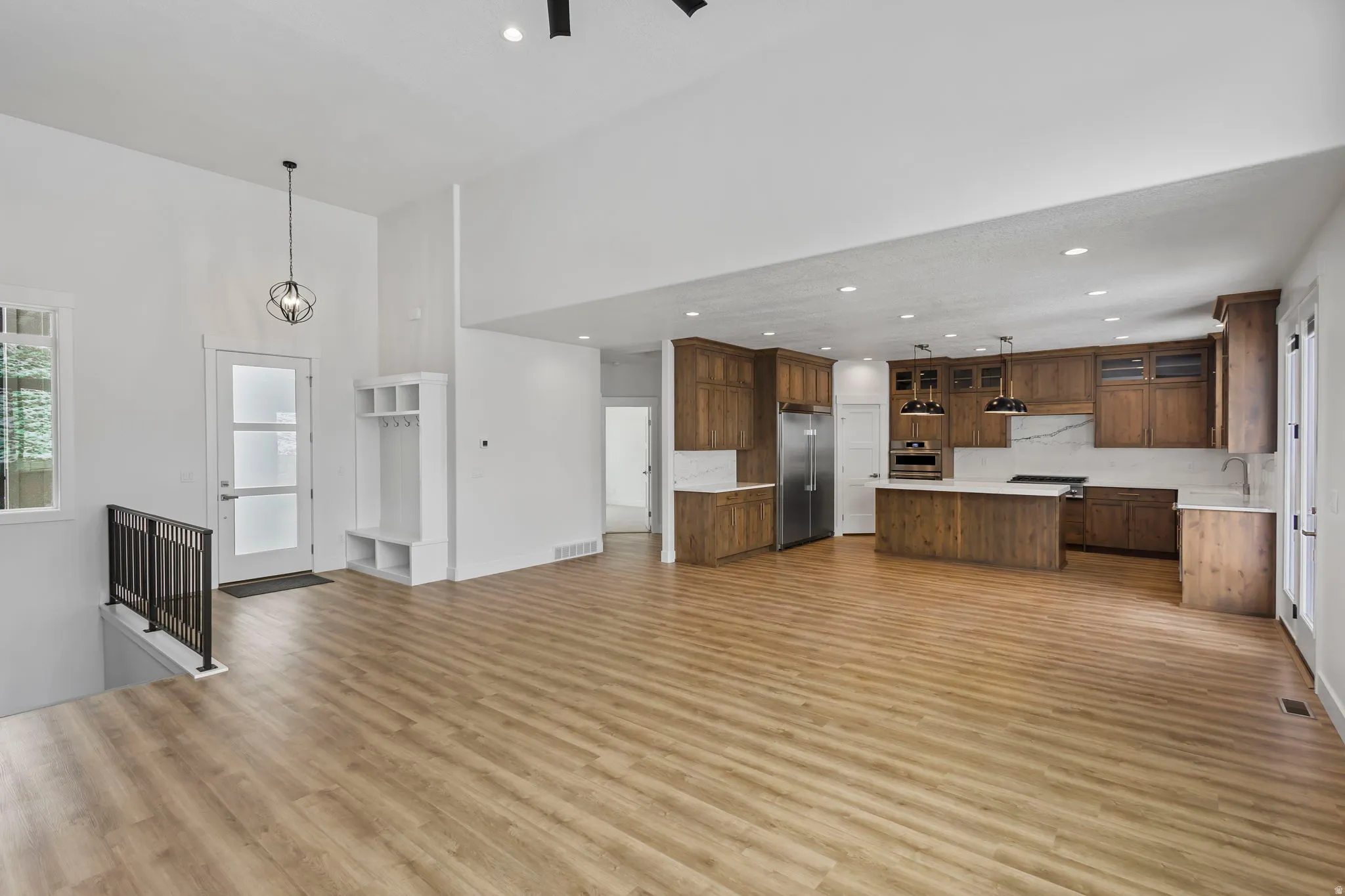Expansive open-concept living area featuring wood-finish flooring and soaring ceilings