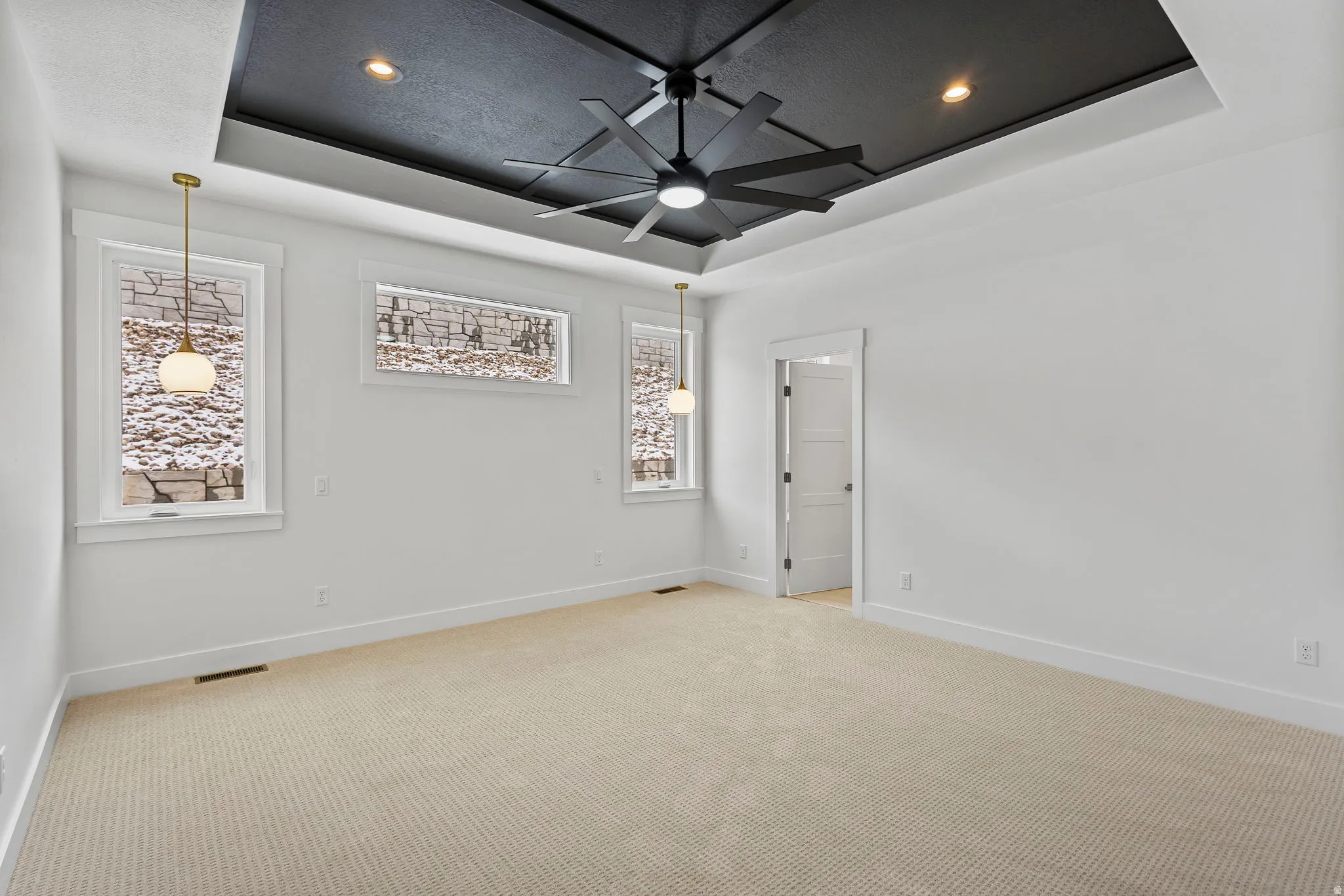 Recessed ceiling featuring a black tray design with a modern ceiling fan and integrated lighting