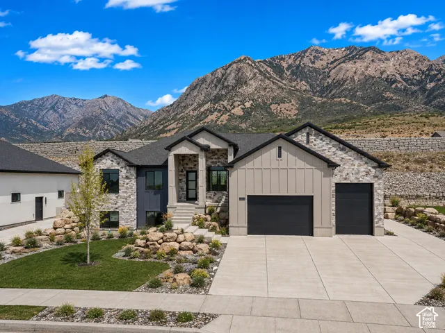 Contemporary stone and siding exterior with a dark shingle roof