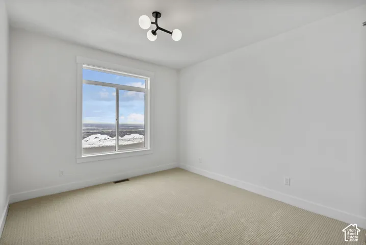 Bright room featuring a large window, neutral wall paint, and a modern ceiling light fixture