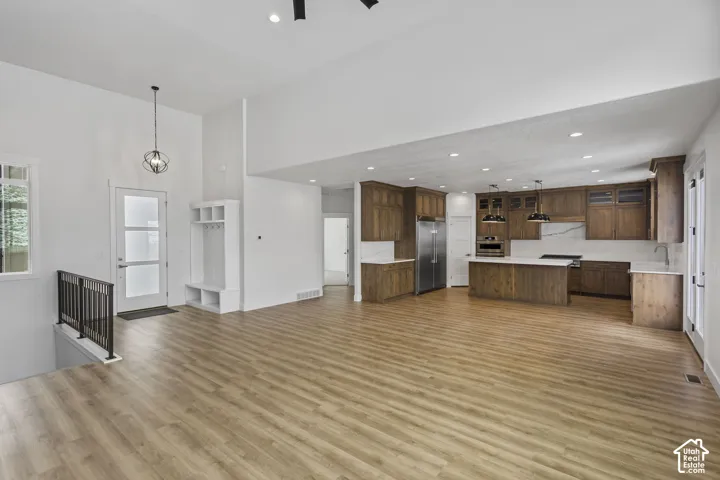 Expansive open-concept living area featuring wood-finish flooring and soaring ceilings