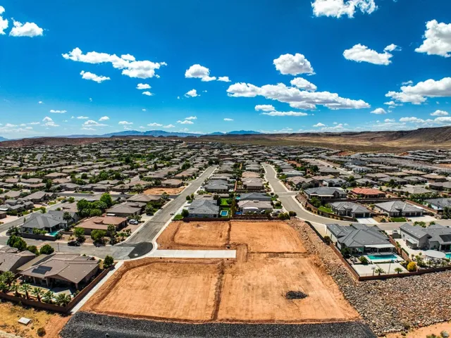 Graded building lots situated within an established residential neighborhood, featuring paved streets and surrounding homes with varied architectural styles