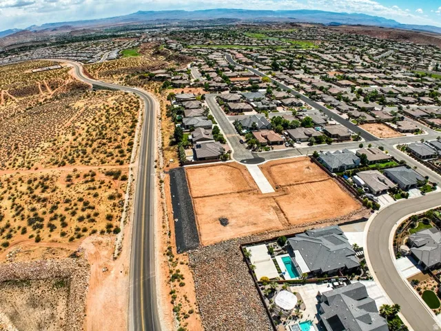 Grades sites for development featuring existing paved road access, surrounded by established residential properties