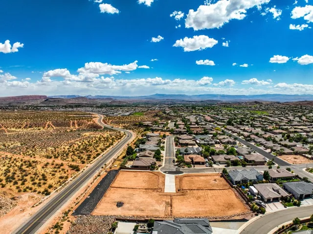 Expansive aerial capture showcasing a residential development bordered by desert landscape and distant mountains