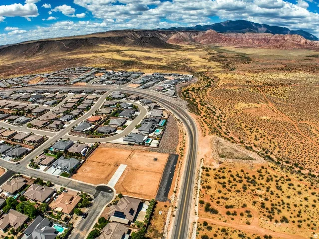 Aerial perspective showcasing a residential development with an established neighborhood alongside undeveloped land