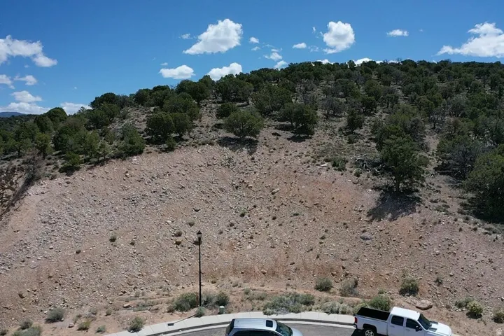 Elevated land parcel featuring natural terrain and mature trees