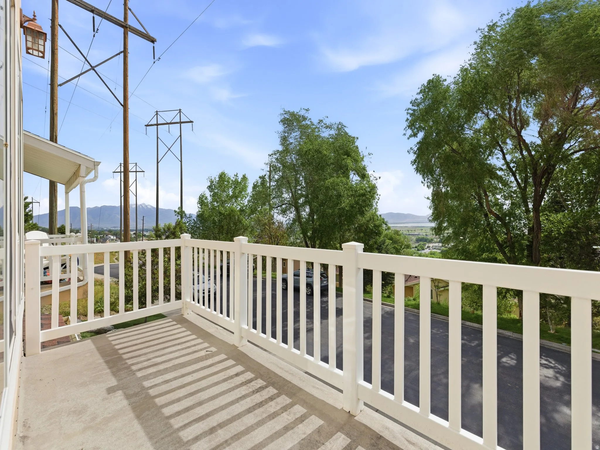 Outdoor balcony with concrete flooring and white railing