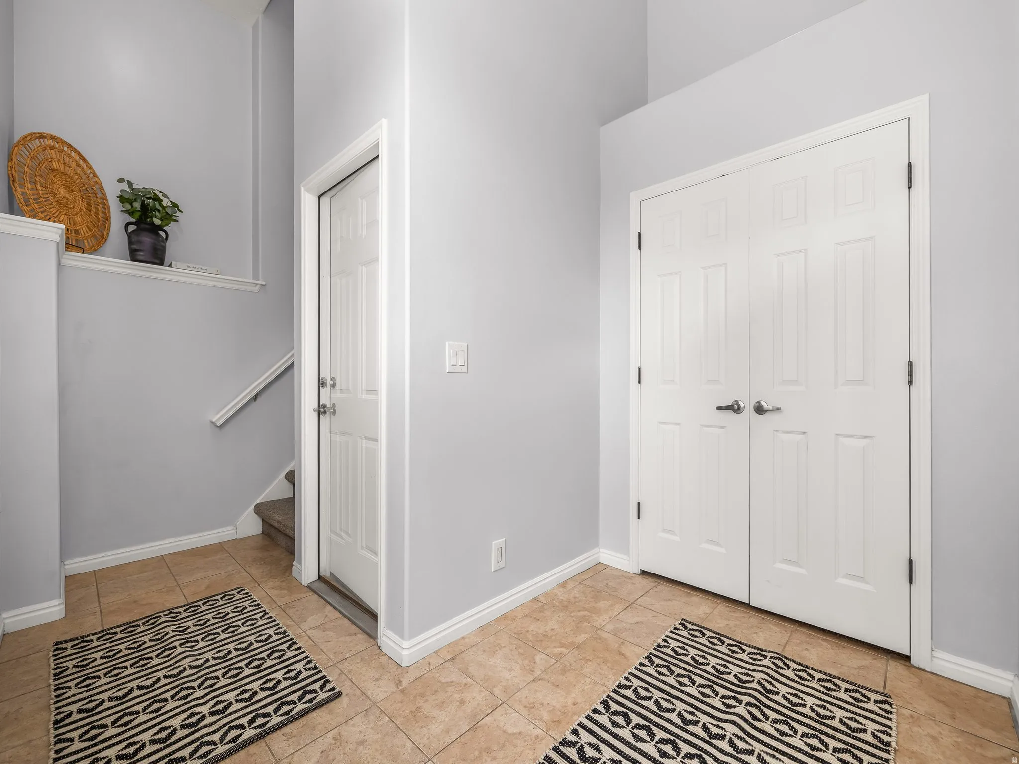 Entry foyer with tile flooring and light gray walls