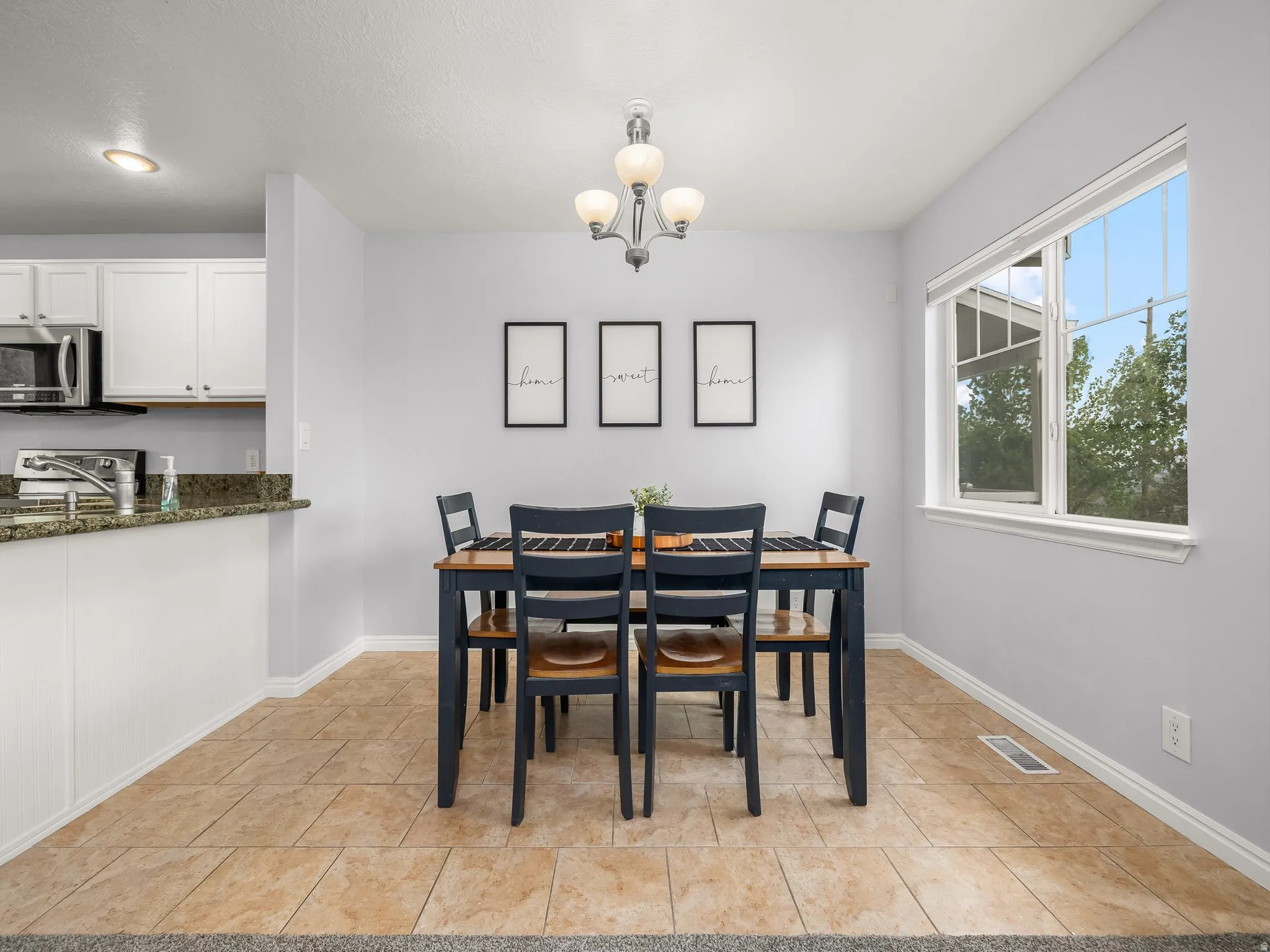 Dining area featuring a contemporary chandelier and a large window