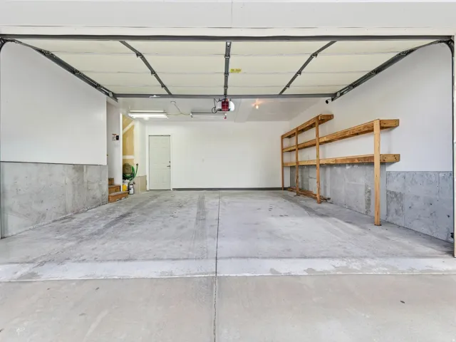 Spacious garage with concrete flooring and exposed concrete foundation walls