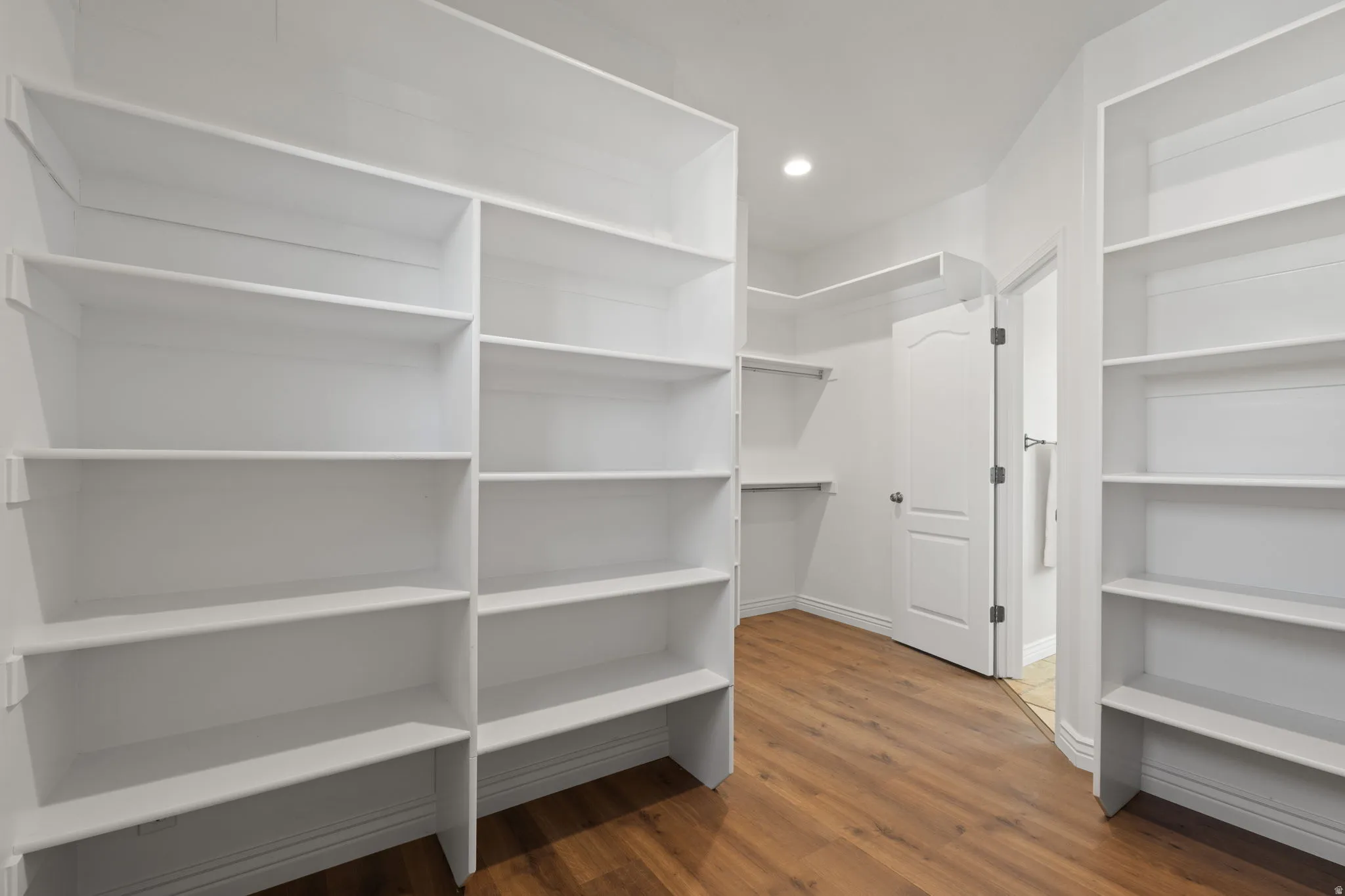 Extra large primary closet with lots of shelves.