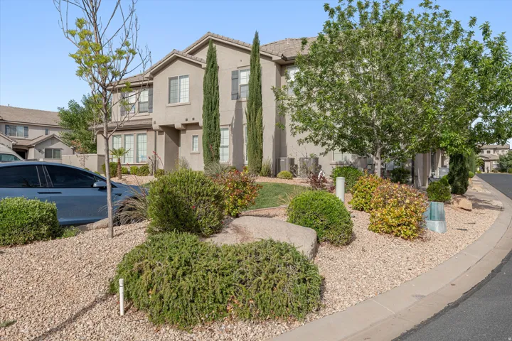 Two-story property featuring a stucco exterior with decorative shutters and a multi-level roofline