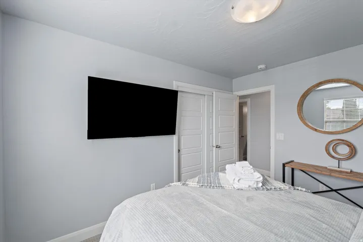 Interior room featuring light gray wall paint, a white textured ceiling, and a wall-mounted television