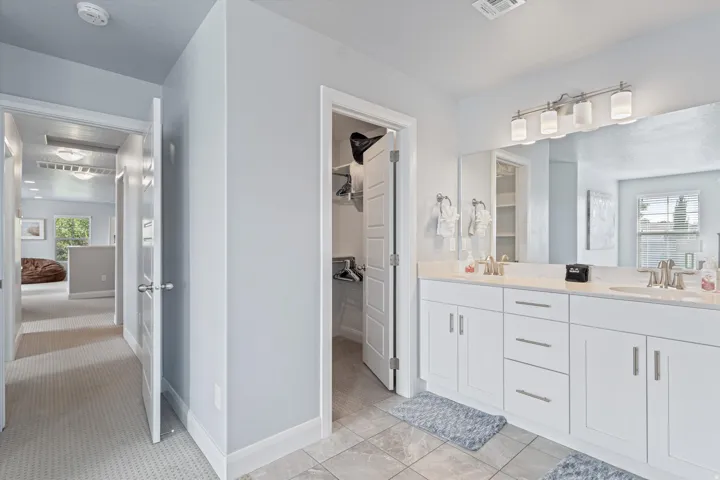 Dual vanity with white cabinetry, integrated sinks, and brushed nickel fixtures