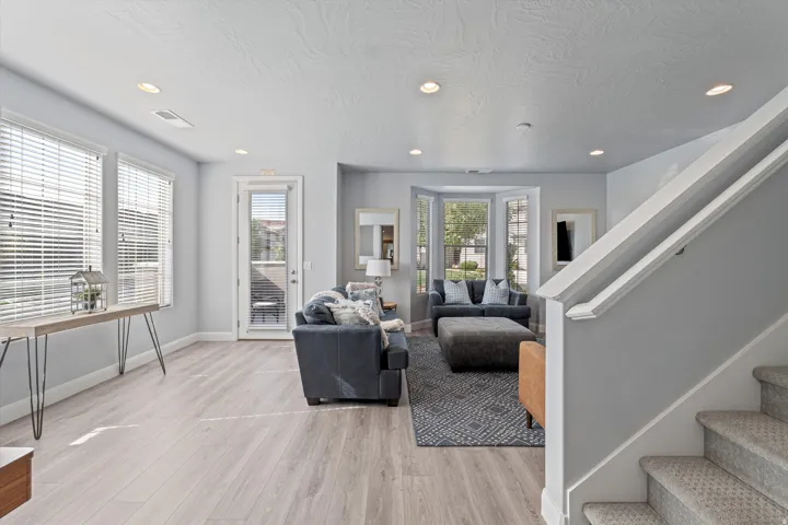 Open concept living space featuring wood-finish flooring, recessed lighting, and a bay window