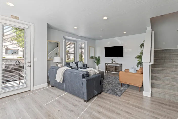 Living area featuring wood-finish flooring, recessed lighting, and a bay window
