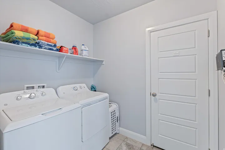 Utility area featuring a built-in shelf, tiled flooring, and a paneled interior door
