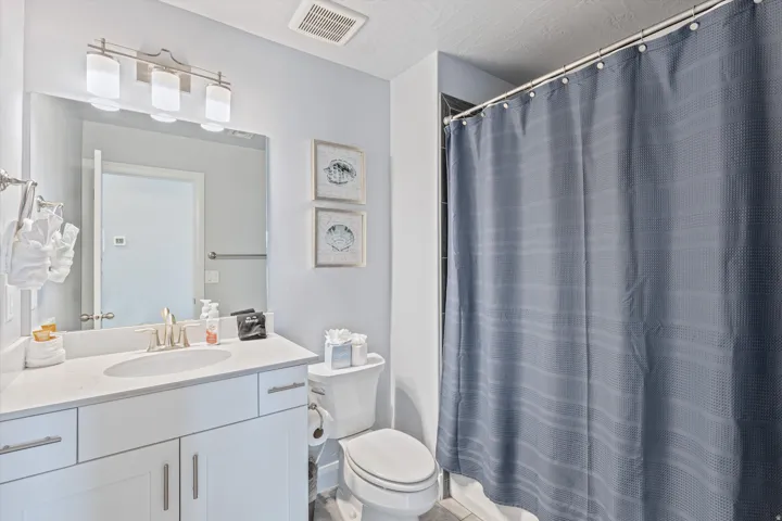 Bathroom featuring a white vanity with a light-colored countertop, an undermount sink, and brushed nickel fixtures