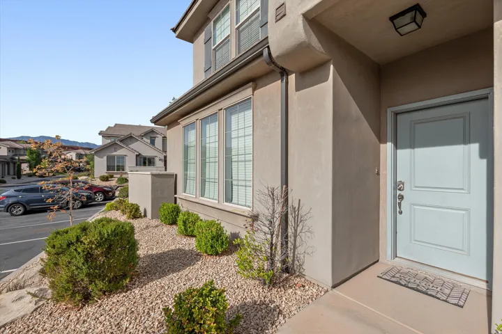 Stucco exterior featuring a light blue entry door with polished hardware