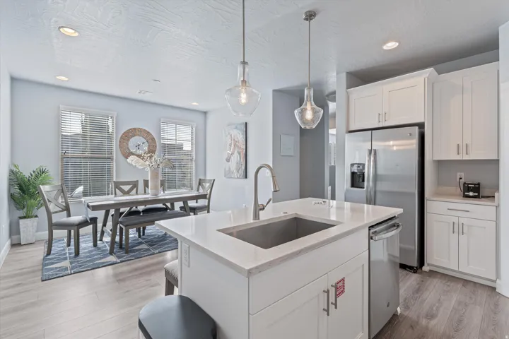 Kitchen island with a stainless steel undermount sink, gooseneck faucet, and quartz countertop