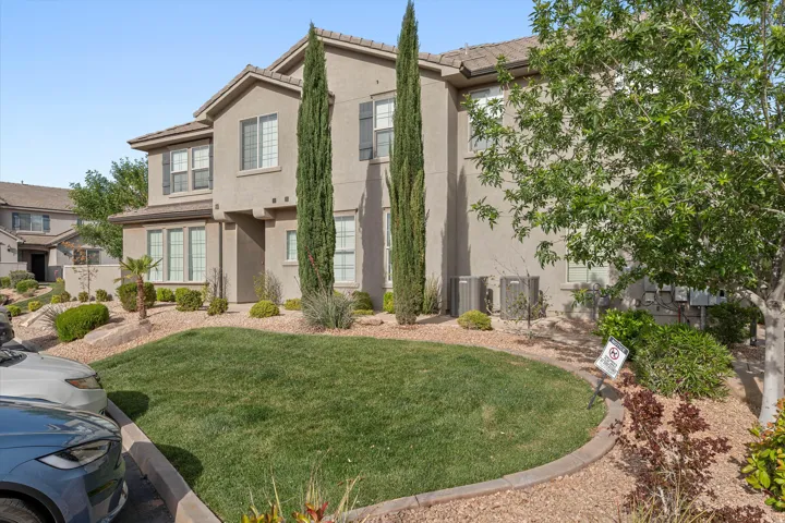 Stucco exterior residence with contrasting dark shutters, a prominent second-story bay window, and a ground-level bay window
