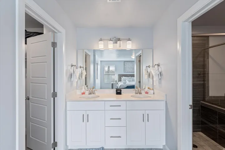 Double vanity with white cabinetry, light-toned countertop, and dual undermount sinks
