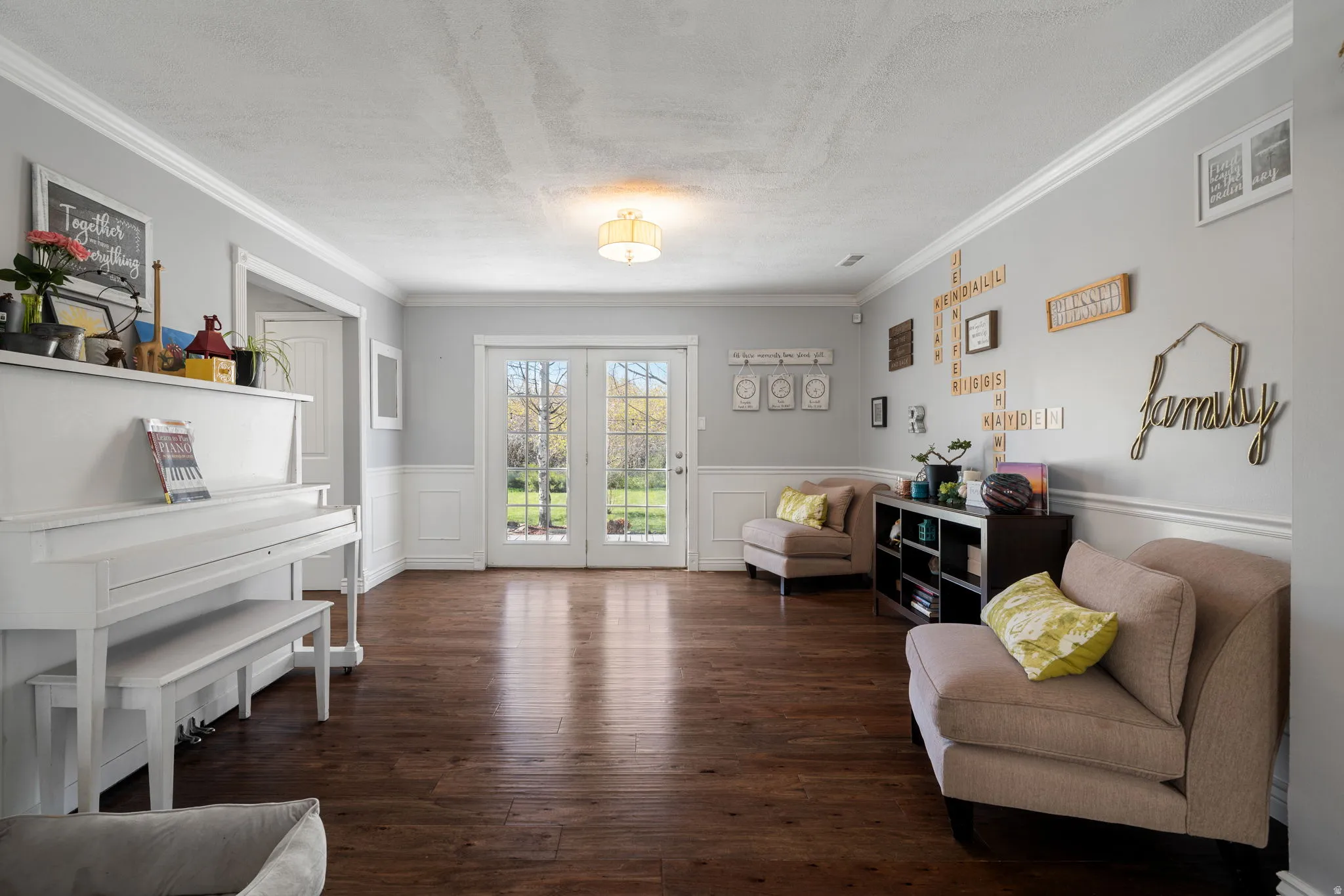 French doors opening to exterior, wood-finish flooring, wainscoting, crown molding, and recessed lighting