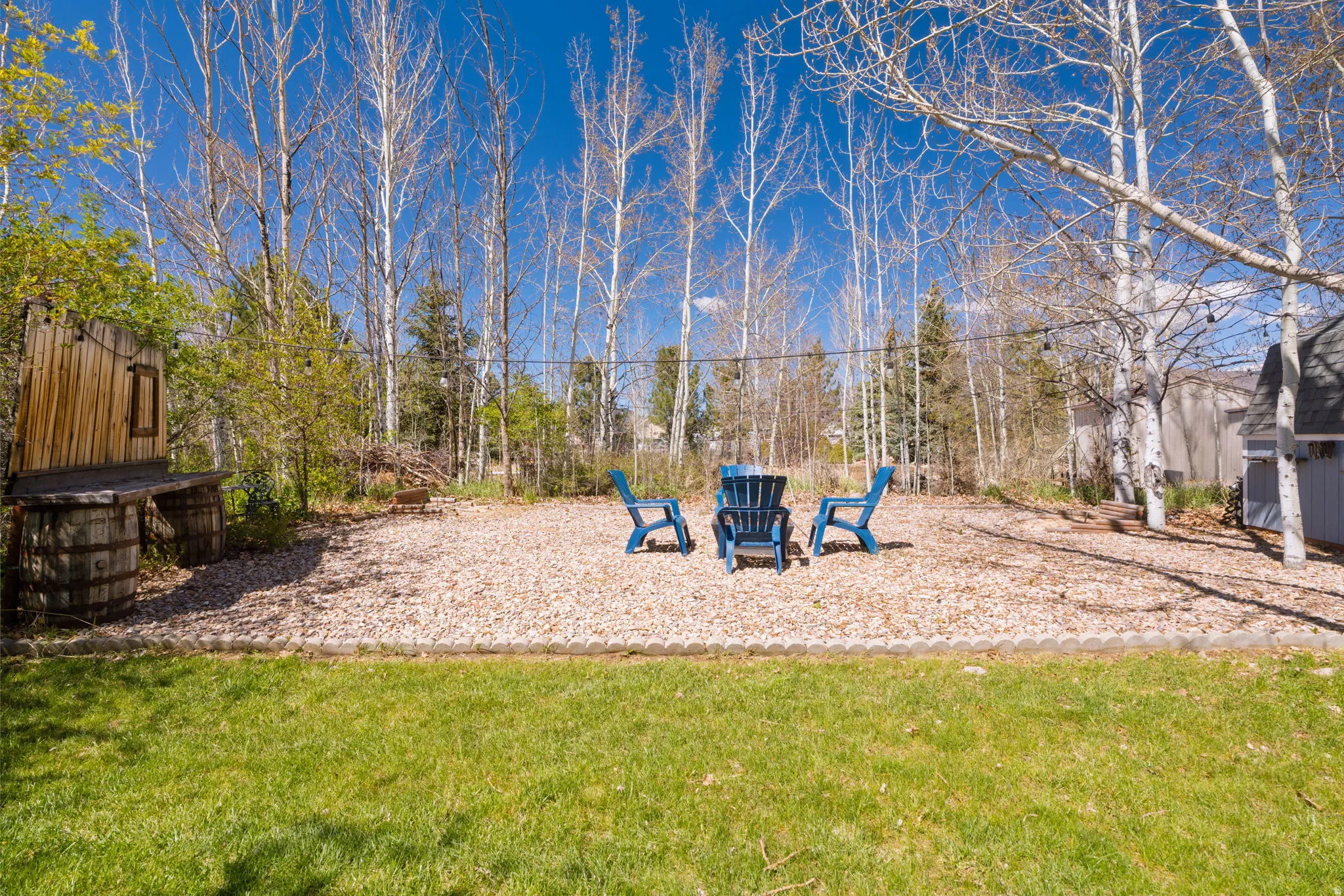 Expansive outdoor area featuring a central gravel patio and a manicured lawn