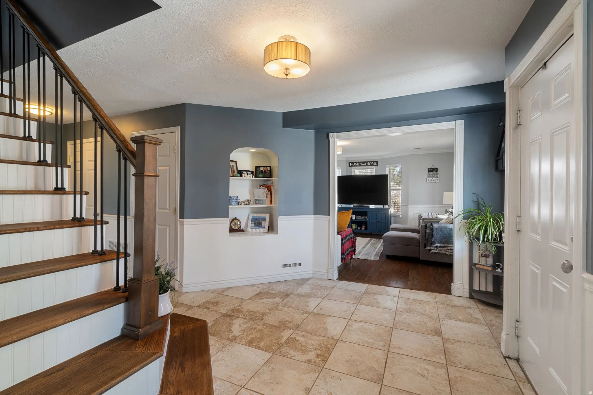 Entryway featuring large format tile flooring and a contrasting wainscoting