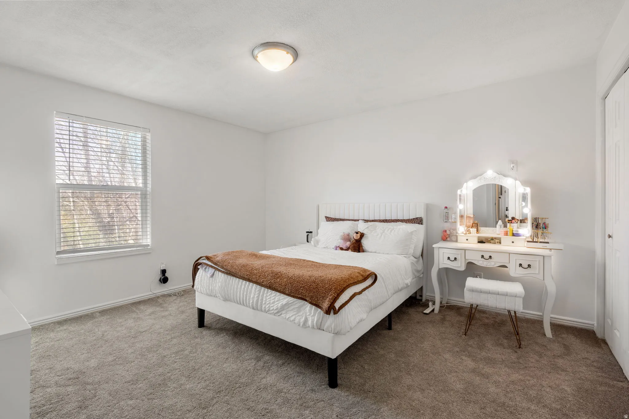 Carpeted room featuring a window with blinds, white walls, and a flush mount ceiling light fixture