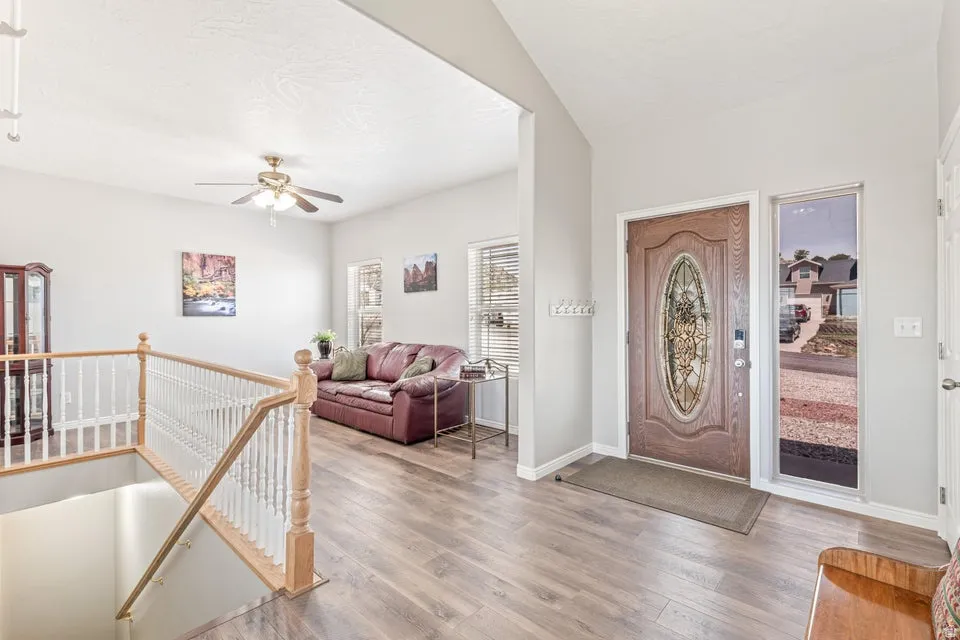 Foyer with decorative glass panel front door, wood-finish flooring, and a sidelight window