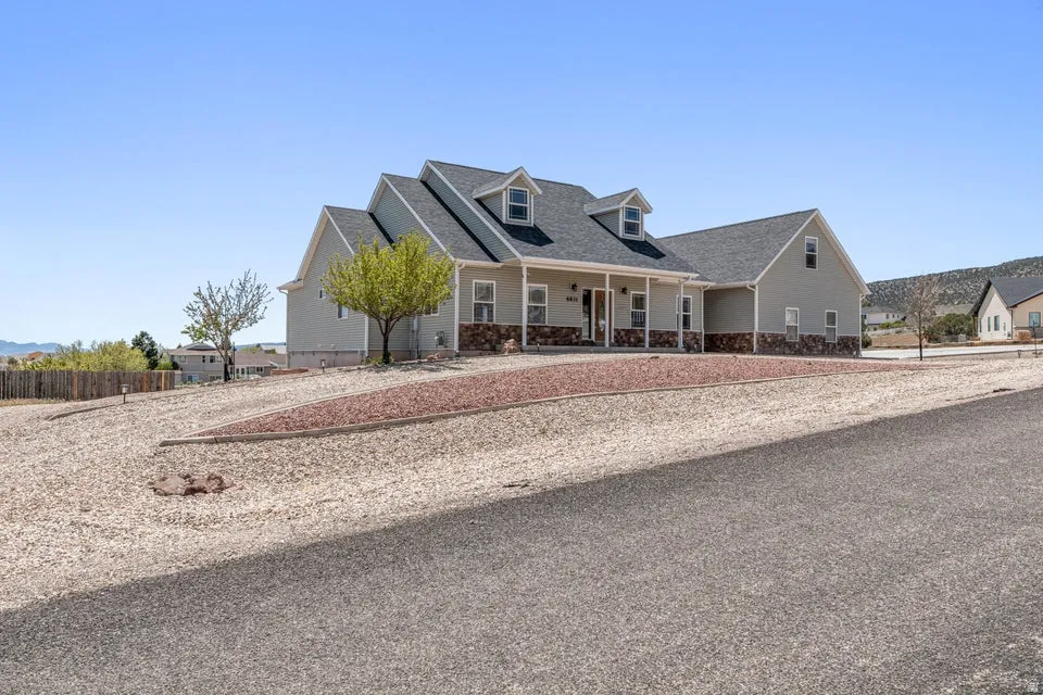Single-story residence featuring light gray siding with a stone veneer foundation