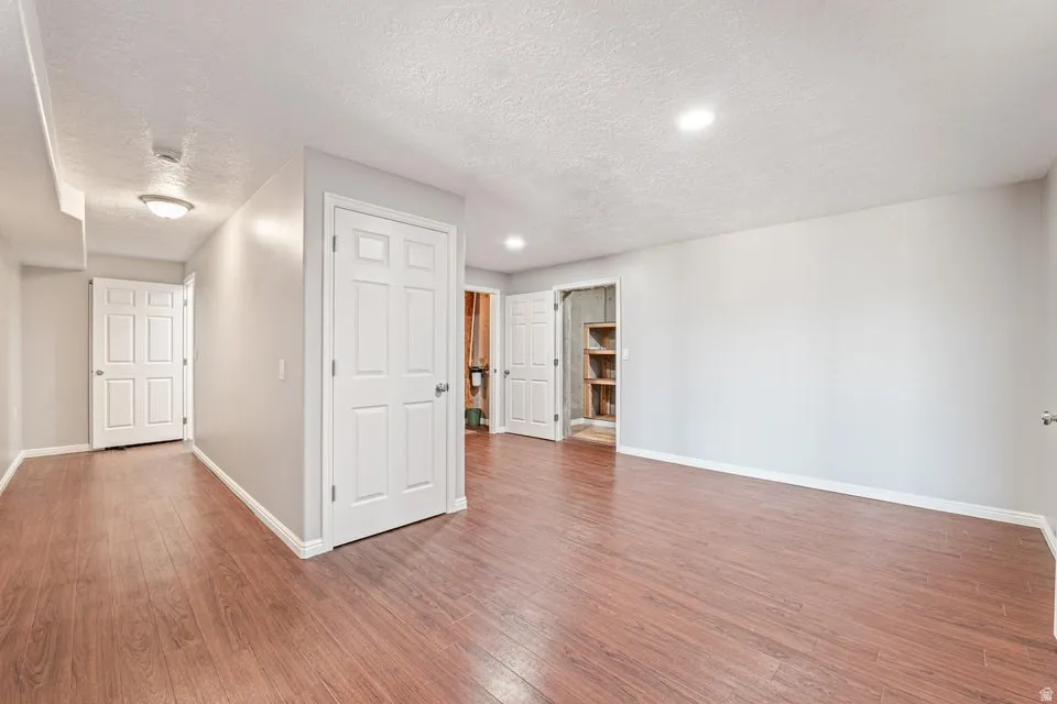 Spacious room with wood-finish flooring, recessed lighting, and light gray walls