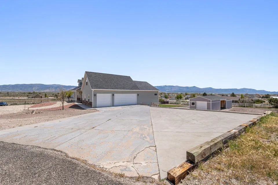 Expansive concrete driveway providing extensive parking and access to a two-car garage