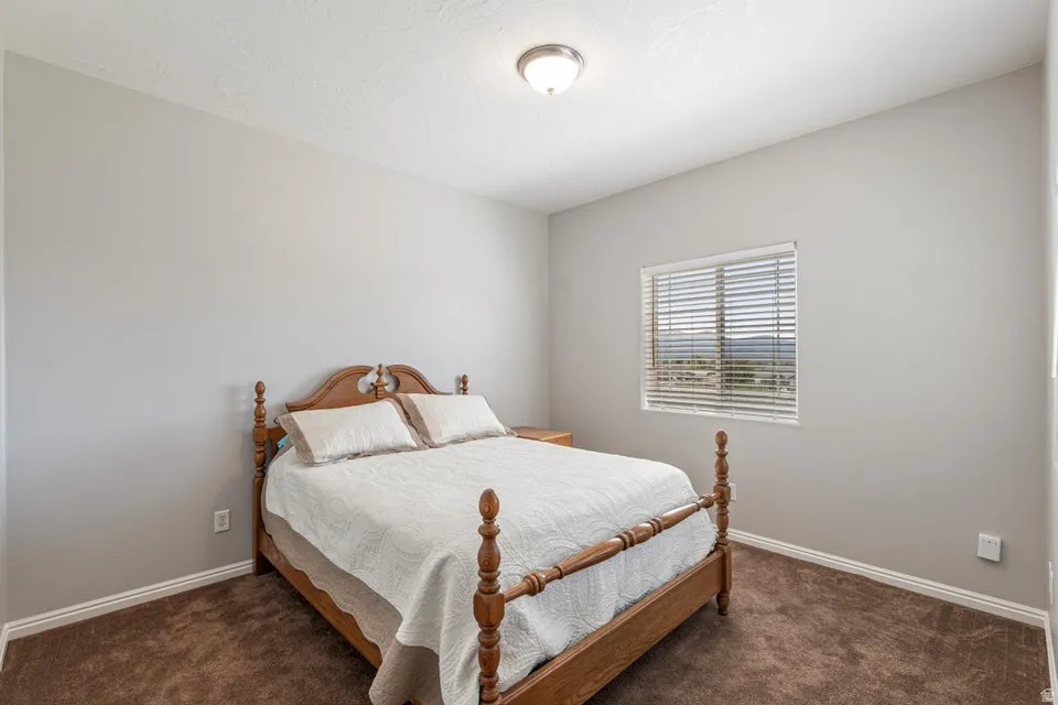 Neutral tone walls with white trim, brown carpeting, and a window with horizontal blinds