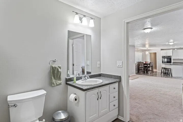 Bathroom vanity featuring a white cabinet, integrated sink, and dark countertop
