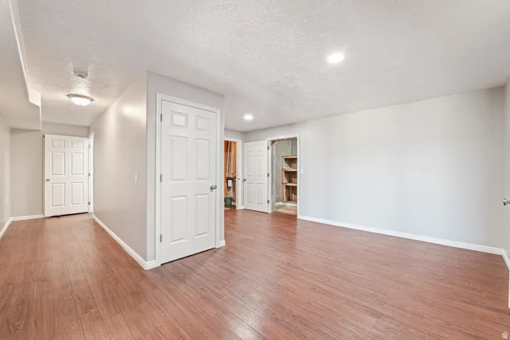Spacious room with wood-finish flooring, recessed lighting, and light gray walls