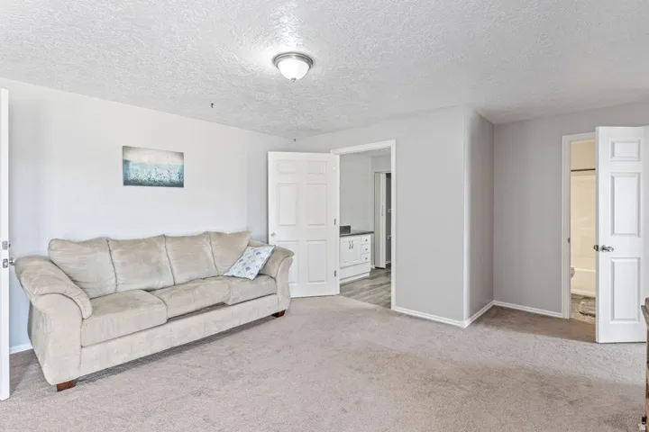 Carpeted room with a textured ceiling and neutral wall tones