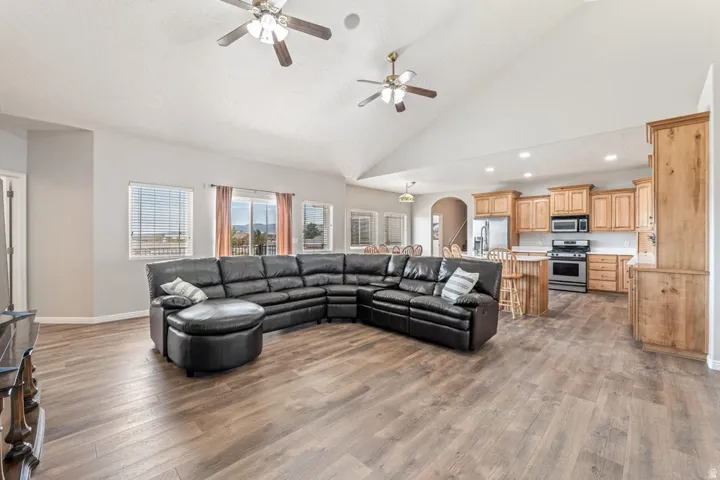 Spacious open-concept living area featuring wood-finish flooring and a vaulted ceiling