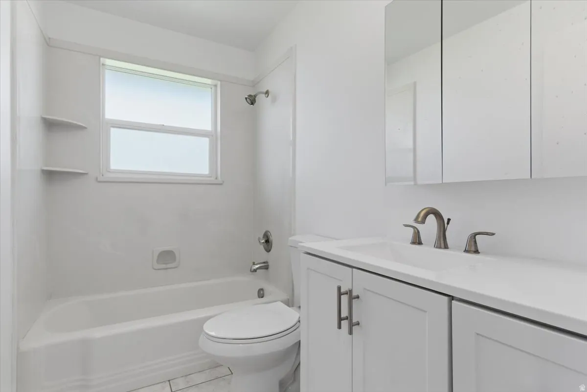 Bathroom featuring a white vanity with integrated sink, brushed nickel faucet, and a large mirrored medicine cabinet