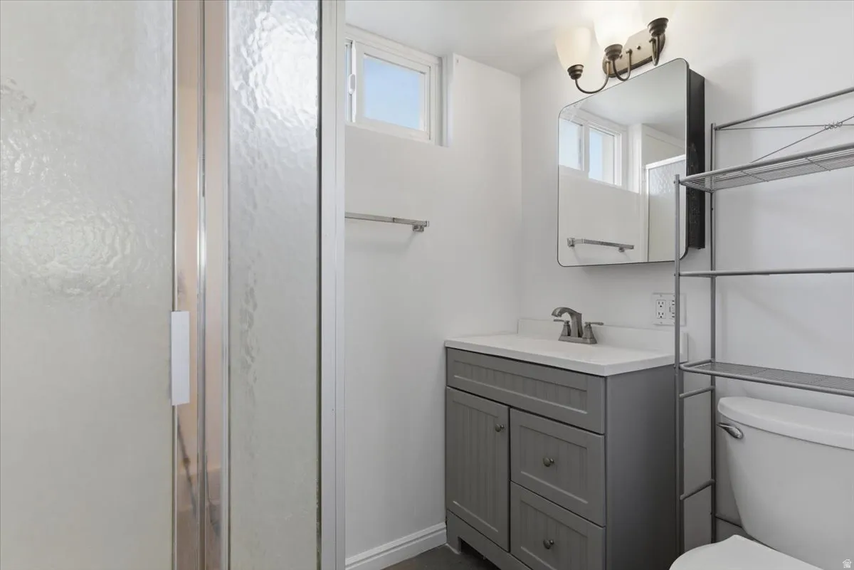Bathroom featuring a gray vanity with white countertop, chrome faucet, and a wall-mounted medicine cabinet