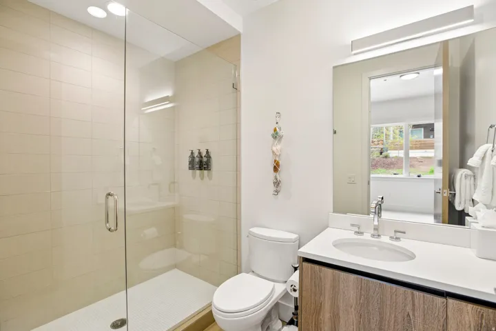 Bathroom featuring a glass-enclosed shower with tiled walls and a built-in shelf
