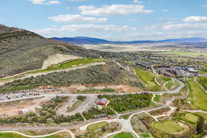 Expansive aerial perspective showcasing a mountainous landscape with a prominent golf course