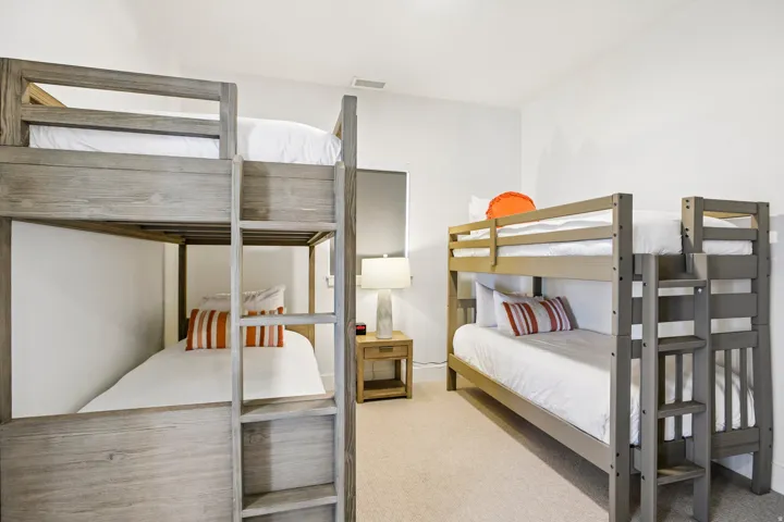Bedroom featuring two bunk bed frames with wood-finish construction and integrated ladders