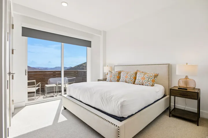 Bedroom with broad sliding glass doors opening to an outdoor patio