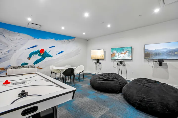 Recreational room featuring a vibrant mural, air hockey table, and foosball table
