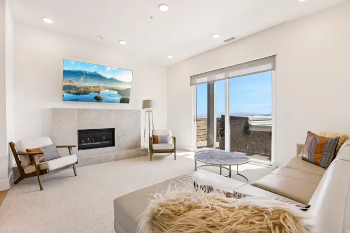 Living area featuring a floor-to-ceiling fireplace with a stone surround, a gas insert, and recessed lighting