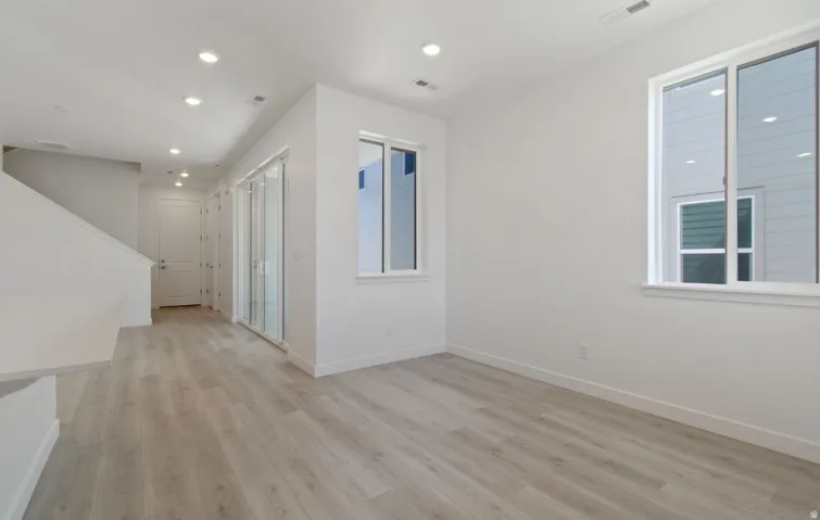 Open-concept room featuring light wood-finish flooring, recessed lighting, and white walls