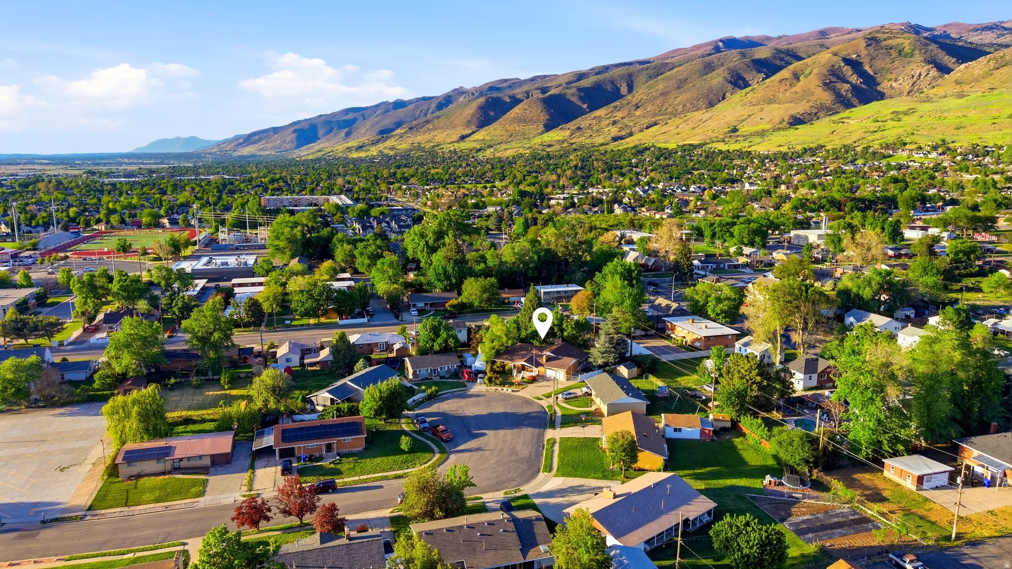 Aerial depiction of a residential neighborhood with a mountainous backdrop